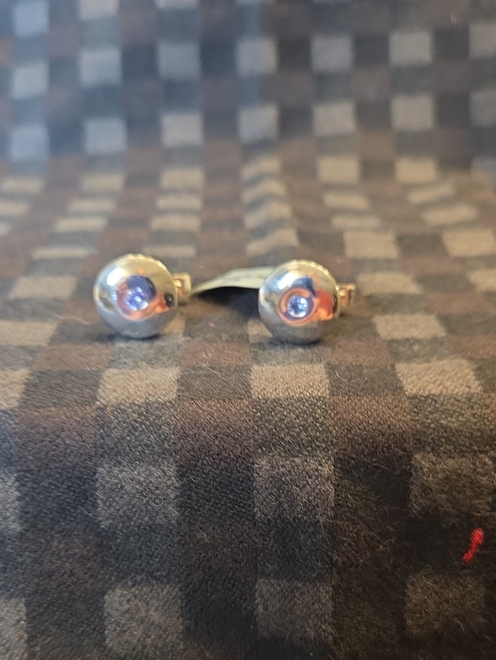 SILVER CUFF LINKS WITH A TANZANITE CENTER STONE ACCENT.